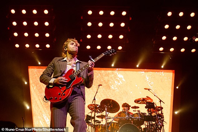 Luke wore a striking pinstripe suit while jamming on his cherry-colored Gibson ES-335 guitar