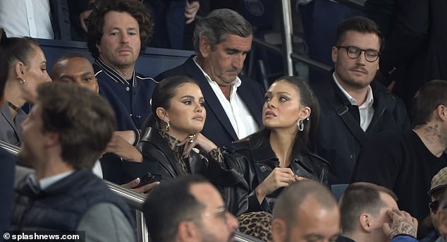 Stylish: Actress and singer Selena, 31, turned heads at the football match as she donned a figure-hugging long-sleeved maxi dress in leopard print