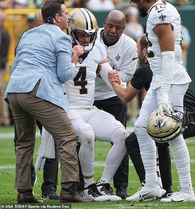 New Orleans Saints quarterback Derek Carr (4) is helped to his feet after an injury