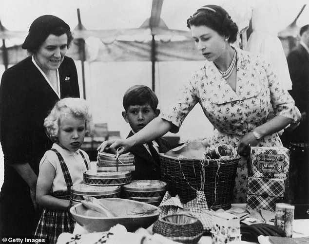 Queen Elizabeth II with Princess Anne, Prince Charles and nanny Helen Lightbody, at a stall during a Sale of Work event at Abergeldie Castle, near Balmoral