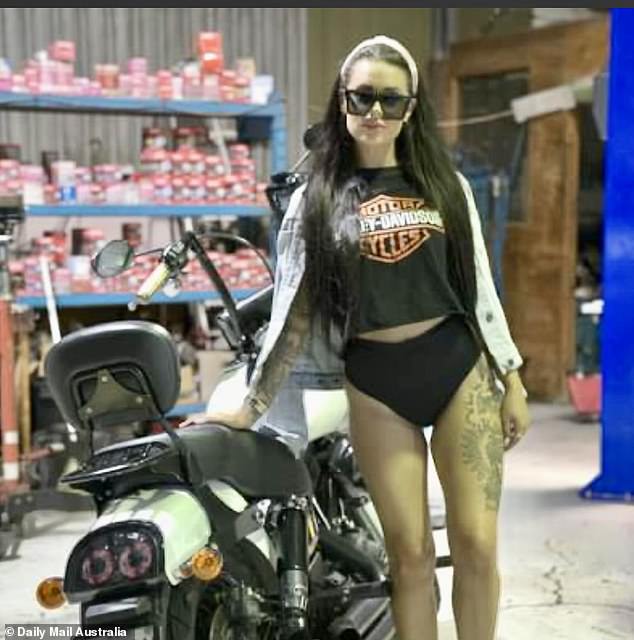 The multi-tattooed real estate agent, Aimee Marsh, is pictured next to a motorcycle