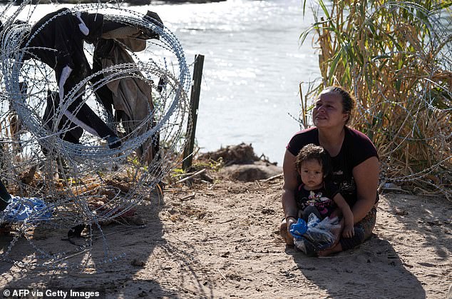 Then mother and daughter were reunited after crossing the dangerous waters and were photographed together near a fence meant to keep migrants out