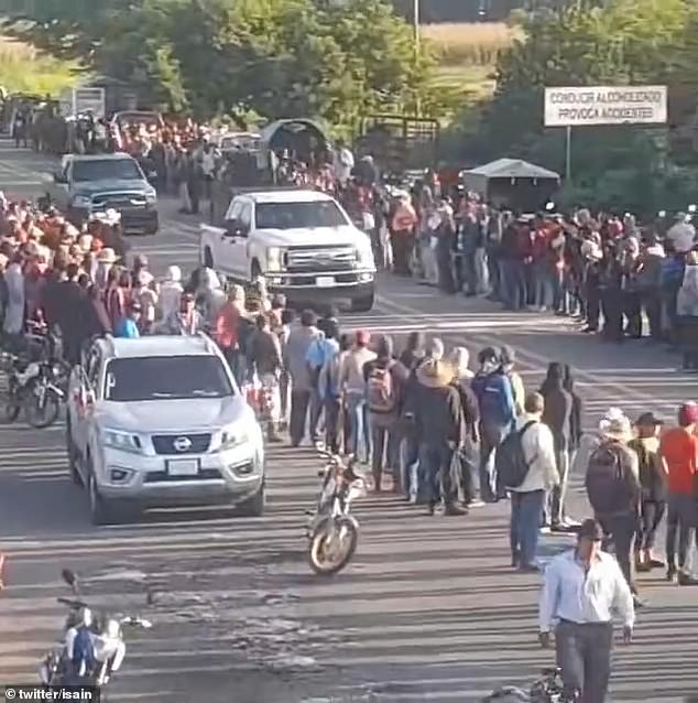 Residents line up on either side of a road during a parade in Chiapas, Mexico, to cheer and applaud members of the Sinaloa Cartel on Saturday after driving out rival members of the Jalisco New Generation Cartel, who had blocked access to the Sinaloa cartel for thirteen days.  state highway 190