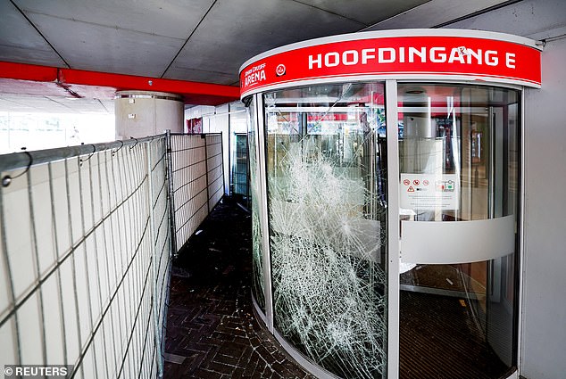 The shattered glass of an entrance to the Johan Cruijff Arena after fans tried to storm in