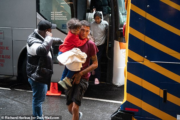 Migrants arrive by bus for processing at the Roosevelt Hotel in Midtown Manhattan