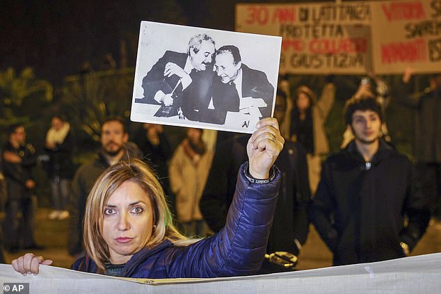 A woman shows a photo that became iconic in Italy - showing key anti-mafia prosecutors Giovanni Falcone (left) and Paolo Borsellino - during a demonstration in Palermo in January