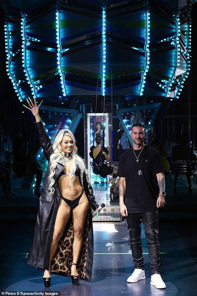 Hostess: Saweetie was in Italy, wearing little more than a bikini, to appear at designer Philipp Plein's (R) SS/24 presentation during Milan Fashion Week on Saturday