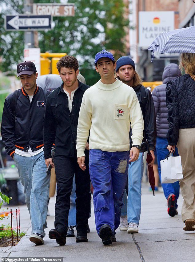 Cozy: Joe was dressed relaxed on the cold day in a thick cream sweater with a red flag design embroidered on the single chest pocket