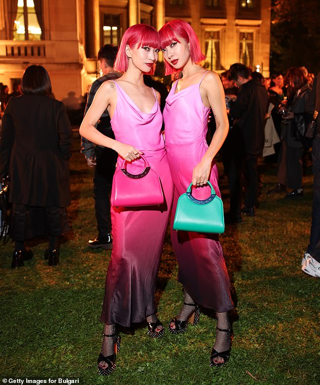 Matching: Twins Ami and Aya matched in pink satin midi dress which they paired with fishnet tights and sky-high heels