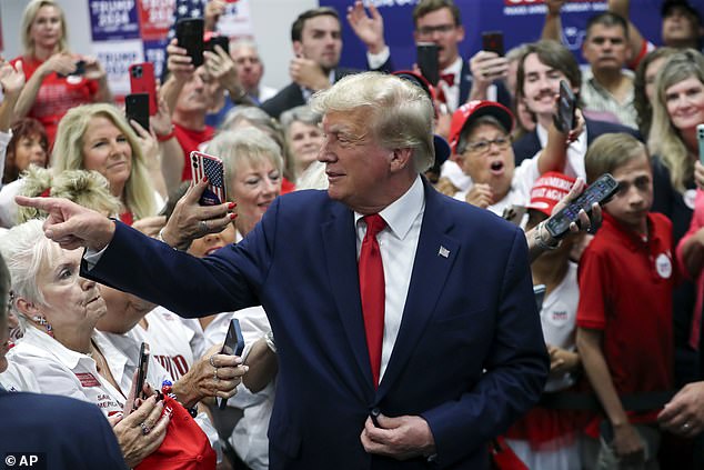 Former President Donald Trump points and waves at a supporter as he campaigns in Summerville, South Carolina, on Monday