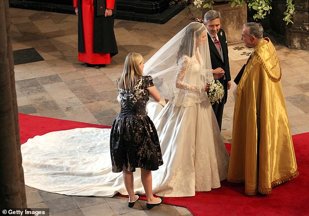 Changing dress: Burton fixes Kate's train as she prepares to walk down the aisle on her wedding day in 2011