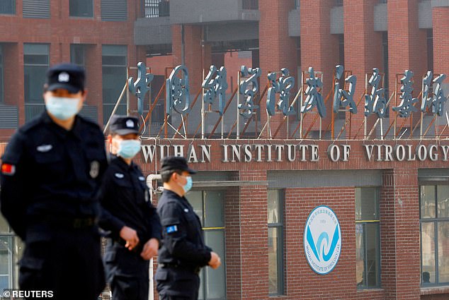 Some experts now say Covid may have originated within the Wuhan Institute of Virology.  Security personnel are pictured here standing guard during a WHO visit in 2021