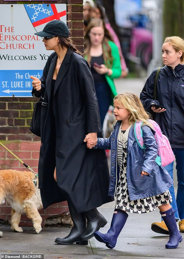 Mother and daughter: The supermodel, 37, showed off her toned legs in a black mini dress and knee-high boots as she held hands with her daughter, whose father is actor Bradley Cooper, 48