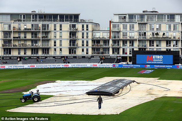 The grounds crew tried to get the blankets onto the field quickly, but the strong wind made that difficult