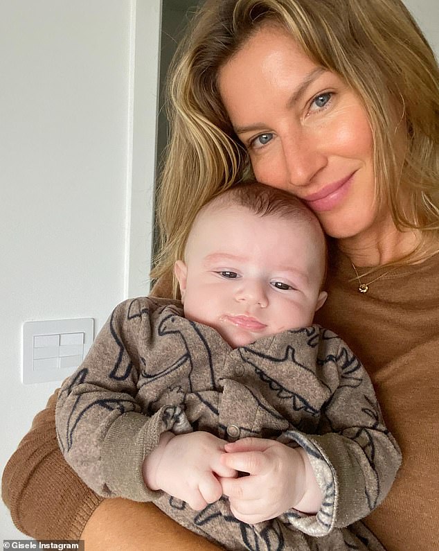 Baby love: Gisele held one of the newest members of her large family