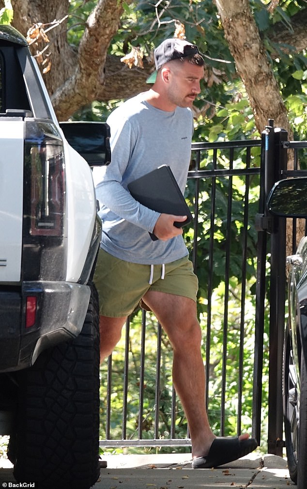 Love story: Travis carried his iPad in one hand as he showed off his toned legs in his olive-colored shorts