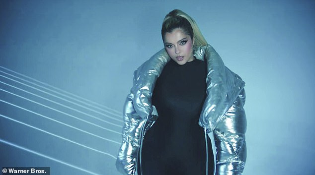 Sing it: As the Say My Name singer sings, she turns around and her outfit changes from a silver strapless dress with beads, to a futuristic silver puffer to a form-fitting black corset dress with a mask