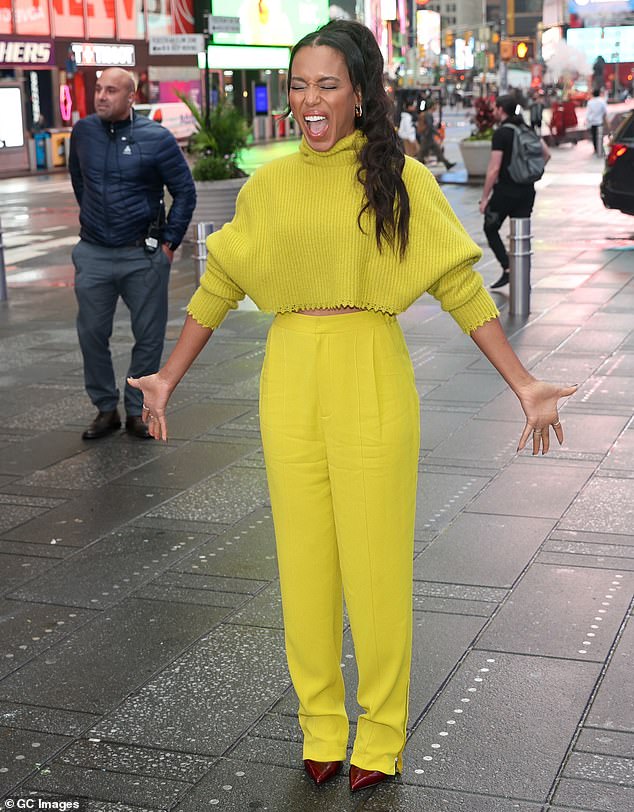 Gorgeous: Kerry looked stunning in a striking yellow and chartreuse ensemble against the gray clouds, appearing in a mustard cropped turtleneck sweater and high-waisted trousers