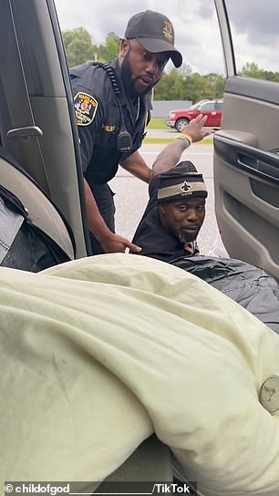 As he falls to the ground, the officer and his colleague put the man on the ground