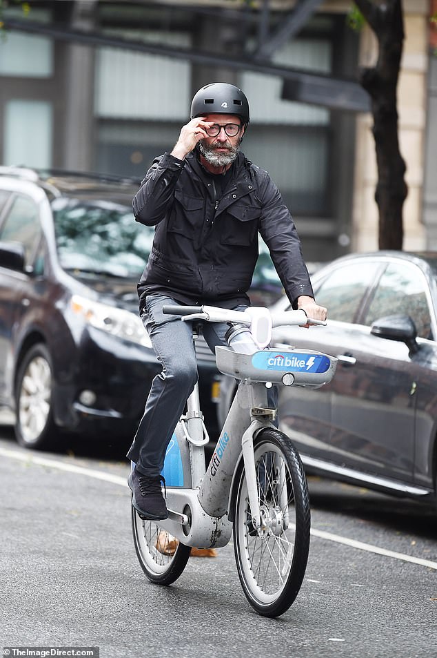 Busy man: the handsome actor, 54, bundled up in a black jacket and gray pants, complete with helmet during his bike ride