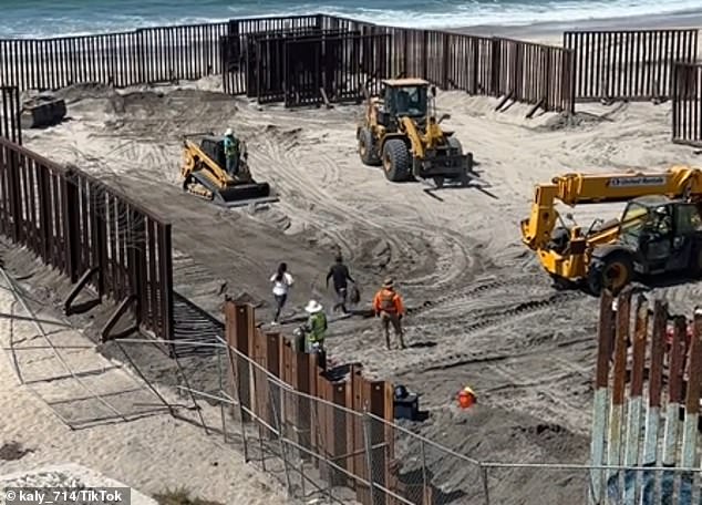 A woman (white t-shirt) follows a man (black t-shirt) as they illegally cross the United States-Mexico border with eight other migrants