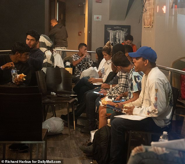 Migrants wait to be processed in a closed bar near the Roosevelt Hotel