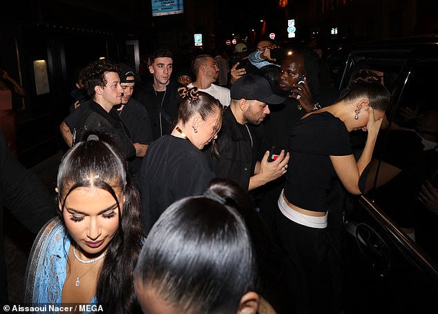 Crowded: The group left the Paris nightclub in a large crowd and then all piled into a waiting car to head back to their hotels