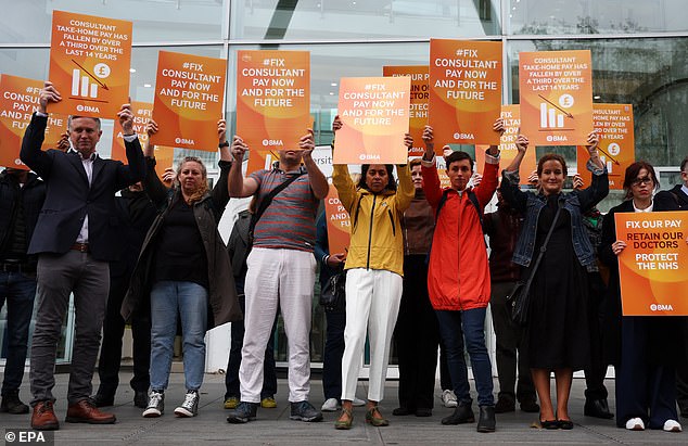 NHS consultants carry signs as they attack a picket outside University College Hospital in London on September 19