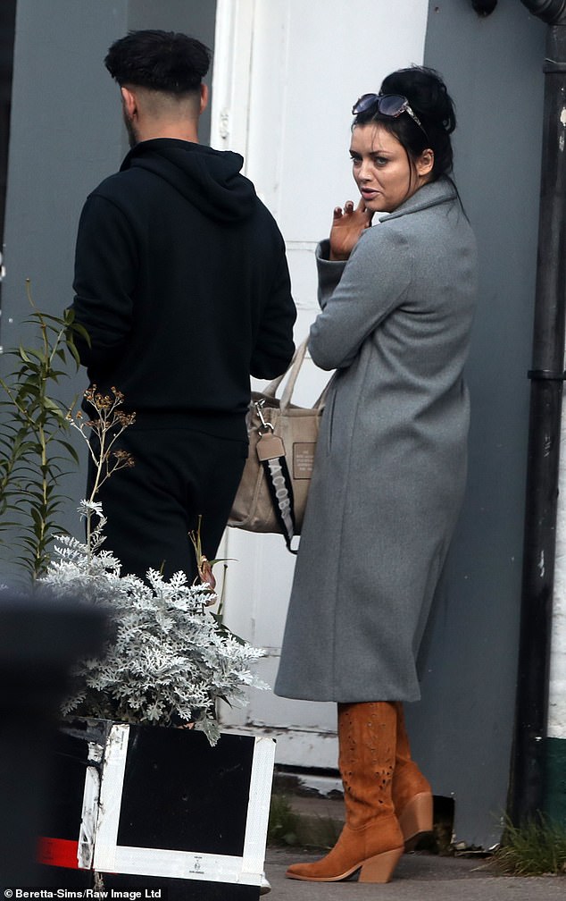 Chilled: Next to her, David cut a casual figure in a black sweater, matching sweatpants and white sneakers