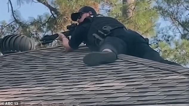 SWAT team members and negotiators spent five hours outside the house (some standing on a roof, pictured above) until Anderson finally surrendered without further incident.