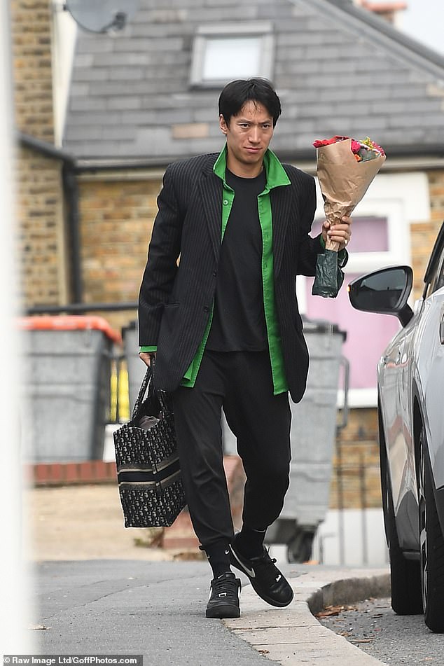 Thoughtful: Angela's professional dance partner Carlos Gu, 39, arrived with a bouquet of flowers in hand