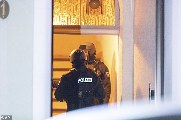 Police officers are seen searching a property in Essen as they conducted raids across Germany