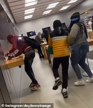 This photo shows one person taking an iPhone from the display