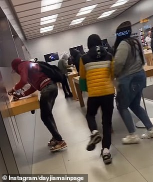 This photo shows one person taking an iPhone from the display