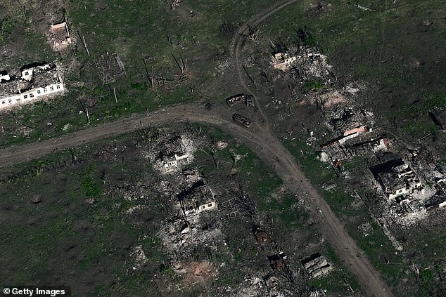 The images show the village in ruins, with destroyed Russian tanks and military vehicles lining the main road