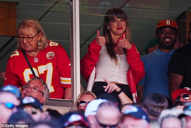 Supportive: The Shake It Off singer gave fans the thumbs up as she watched Travis with his mother Donna