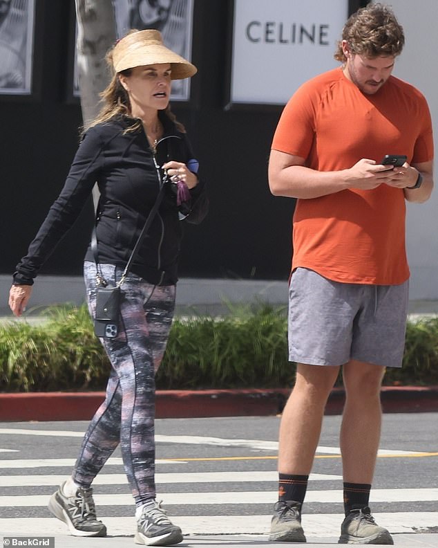 Looking fantastic: His proud mother was the picture of glee as she sauntered next to him, draping her own lithe body in a set of cushioned workout gear