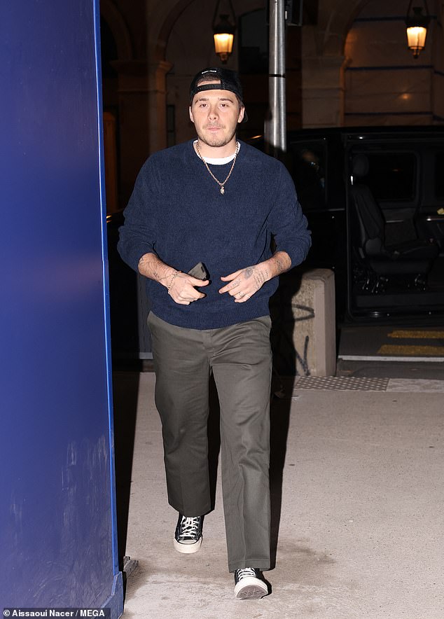 Casual: She cut a very glamorous figure for the evening as she was joined by boyfriend Brooklyn Beckham, who cut a casual figure in a navy blue sweatshirt and gray trousers