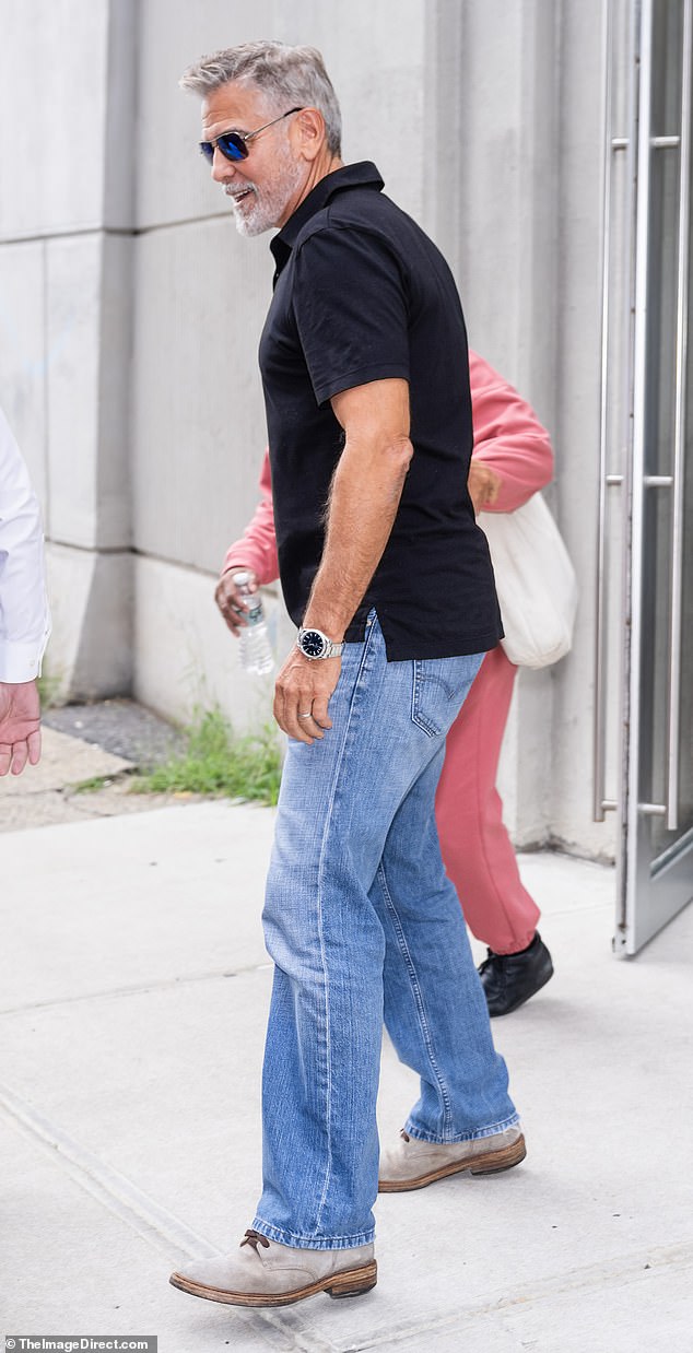 Looking great: The silver fox looked handsome in a black polo shirt and light wash jeans