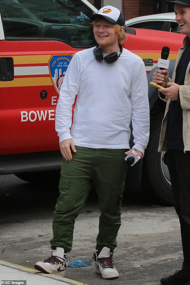 Having fun: Ed appeared cheerful while filming the scenes and was photographed stopping passersby for interviews