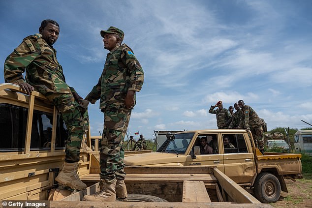 Somali National Army (SNA) soldiers and Somali security forces load vehicles at the airport in Baidoa, Somalia