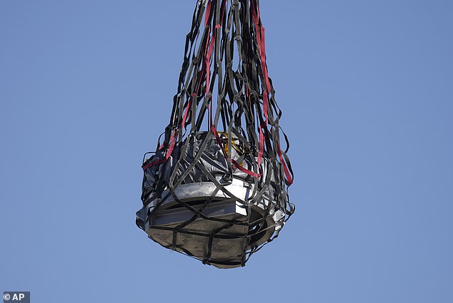 A helicopter delivers a space capsule containing NASA's first asteroid samples to a temporary cleanroom at Dugway Proving Ground, Utah, on Sunday