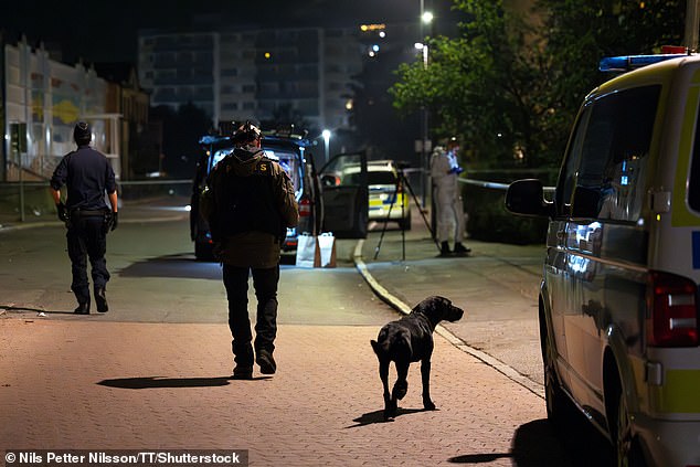 One man was killed and another injured in a shooting in Jordbro, south of the Swedish capital: officers and police dogs pictured at the scene on Thursday morning