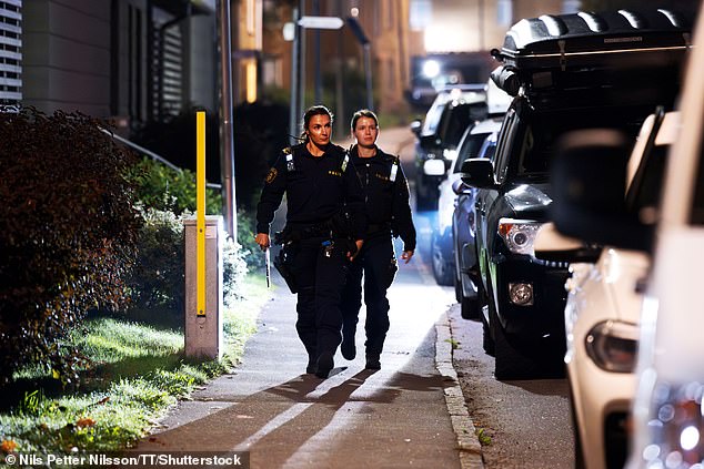 One man was killed and another injured in a shooting in Jordbro, south of the Swedish capital: officers are pictured at the scene on Thursday morning