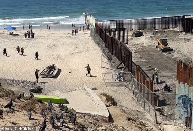 A viral TikTok video posted Monday showed at least 10 migrants and a dog running through an open section of a steel border barrier under construction at the Tijuana-San Diego border.