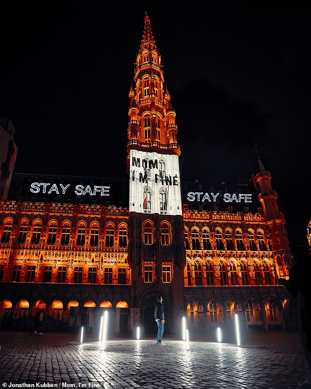 This striking image shows Jonathan's 'Mom, everything is fine' message displayed in lights on the Grand Place in his hometown - Brussels