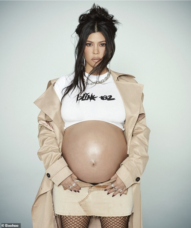 Stunning: The TV personality showed off her bump in a cropped white Blink-182 T-shirt which she paired with a beige mini skirt and a trendy trench coat