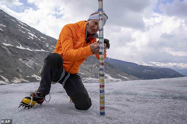 Matthias Huss, head of the Swiss glacier monitoring network GLAMOS, checks the thickness of the Rhône Glacier near Goms, Switzerland