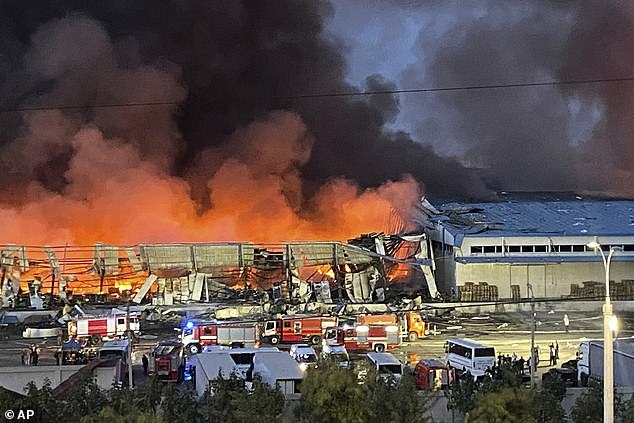 Flames and smoke rise as firefighters extinguish a fire at a warehouse site in Tashkent, Uzbekistan