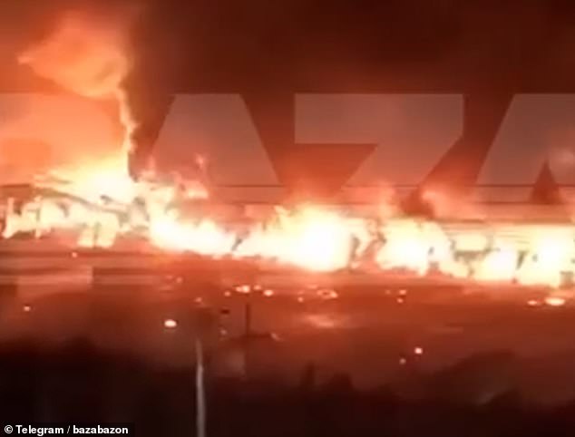 The remains of the warehouse can be seen burning after the massive explosion that rocked the city